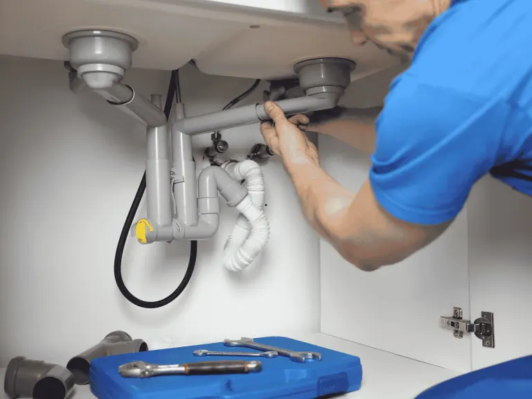 Plumbing repair beneath a kitchen sink in Mercer Island