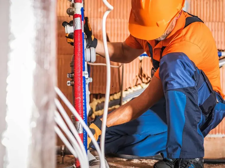 Plumber working on water-supply pipe replacement during a repiping project